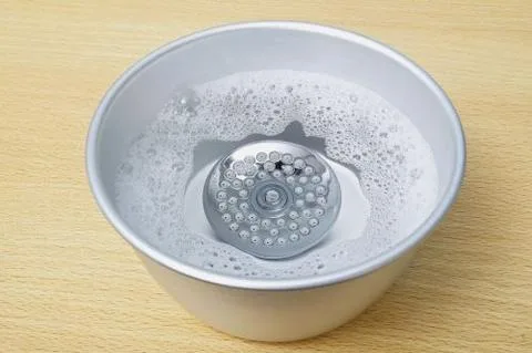 Détartrage d'un pommeau de douche dans du vinaigre blanc pour enlever le calcaire